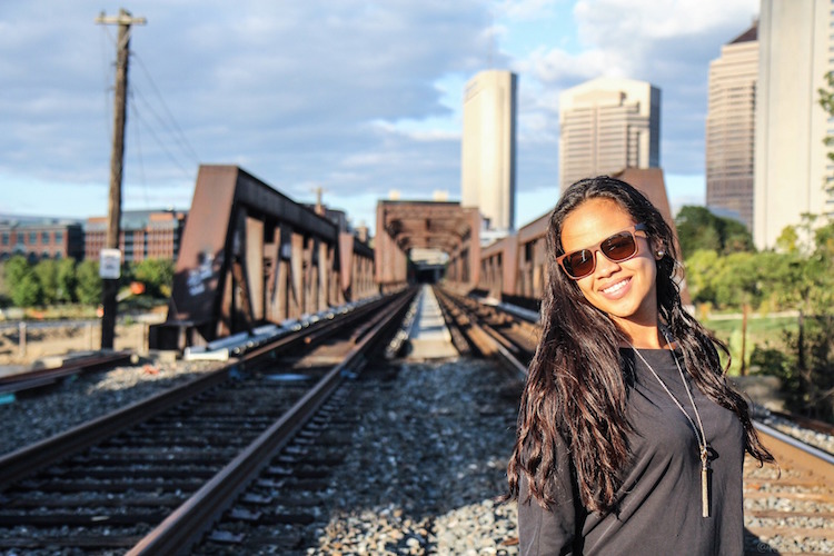 Confident woman on railroad tracks